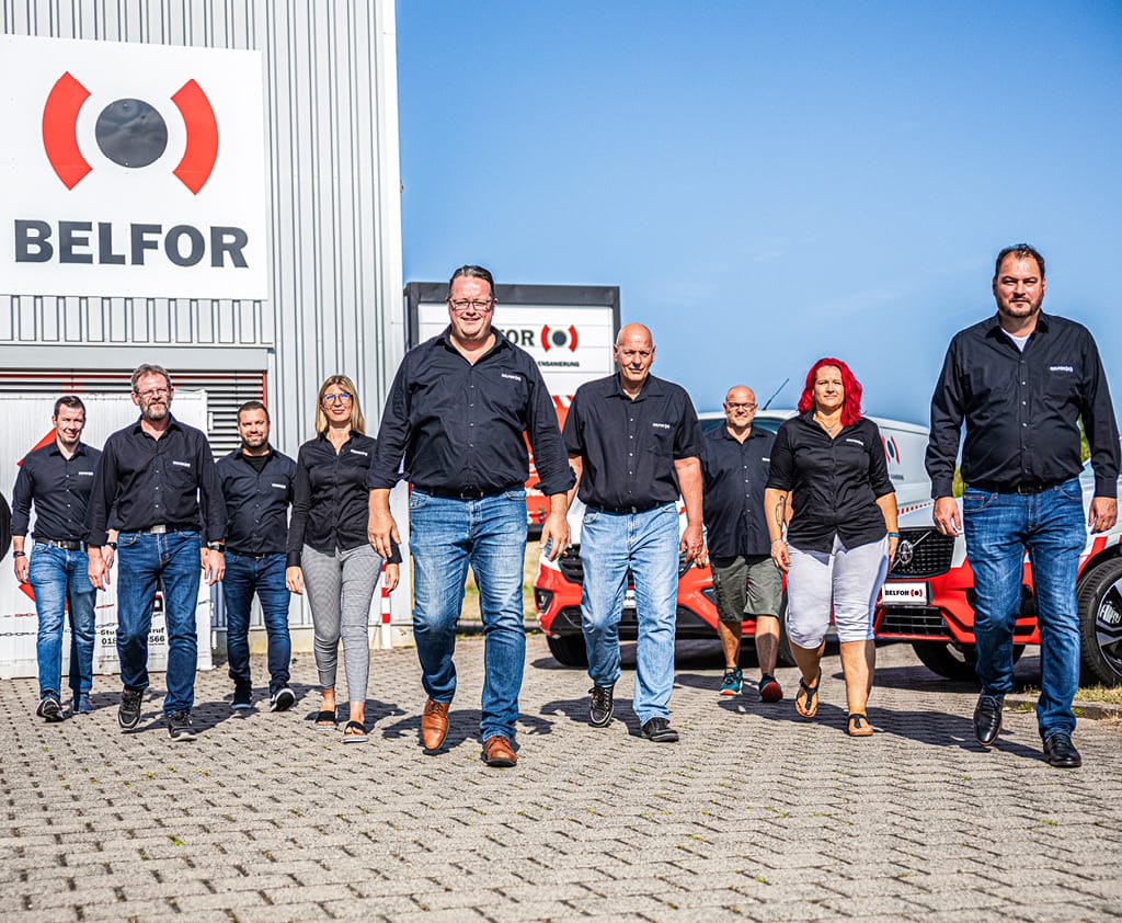 A group of BELFOR Employees walking in front of a BELFOR branch_Black-modul_1024x842px