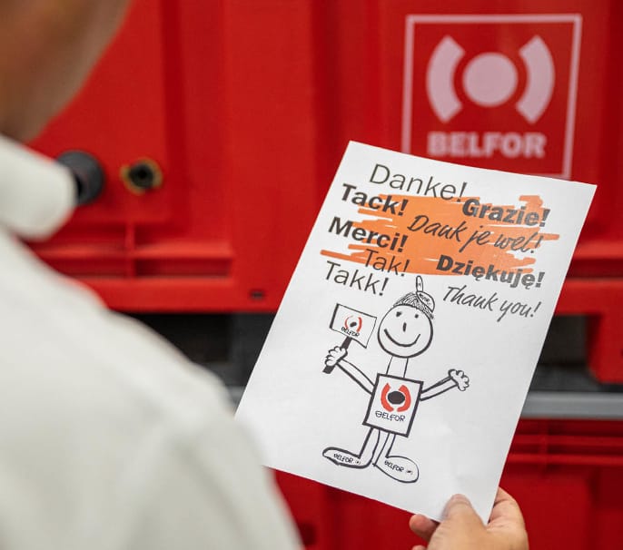 A man holding up a paper with a drawing